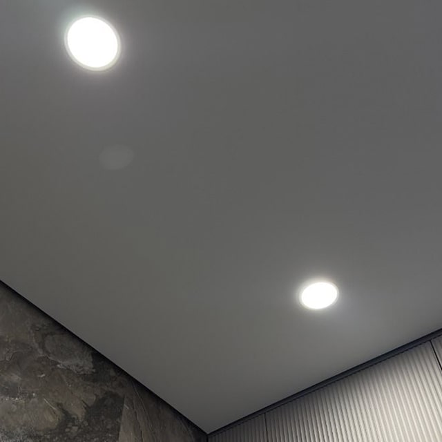 Контурный профиль и точечные светильники на бежевом натяжном потолке